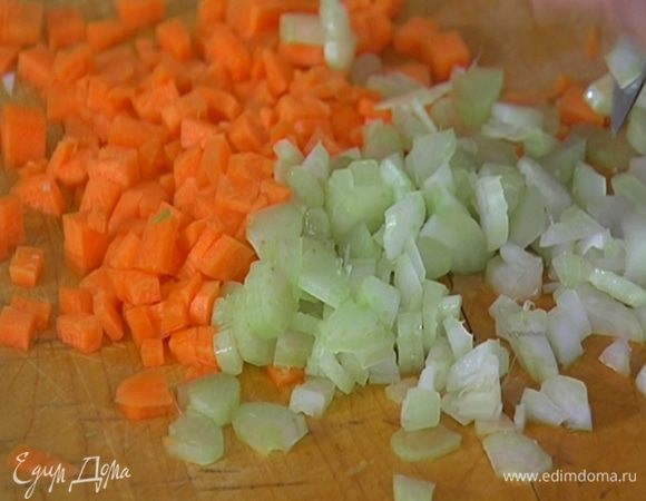 Порезать морковь и сельдерей маленькими кубиками, добавить в кастрюлю с луком, перемешать и обжаривать 3–5 минут на медленном огне.