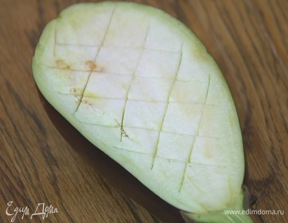 Баклажаны вместе с плодоножкой разрезать вдоль пополам и сделать диагональные крестообразные надрезы, стараясь не прорезать кожицу.