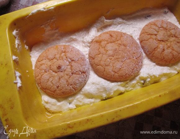 Возьмите силиконовую форму, смажьте ее растительным маслом и выложите в нее половину творожной массы. Печенье склейте с помощью джема и выложите поверх творожной массы в форму. Оставшиеся промежутки можно тоже заполнить джемом.