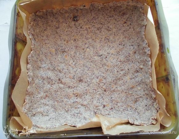 Выложить основу в форму. Я использовала квадратную силиконовую форму размером 20*20 см, которую для удобства застелила еще бумагой для выпечки. Сделать небольшие бортики. Мне хватило "теста" в самый раз! Вынести основу в холодильник, пока будет готовиться начинка.