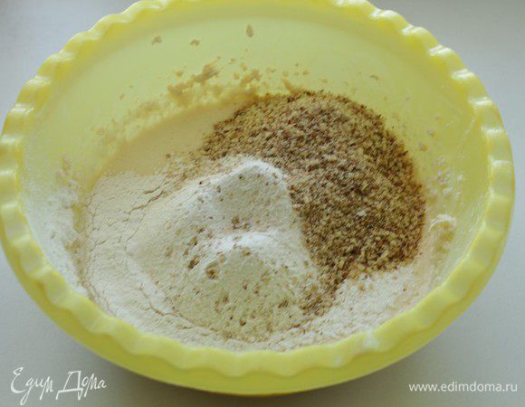  К масляной смеси просеять муку с разрыхлителем, добавить молотые  орехи , перемешать.