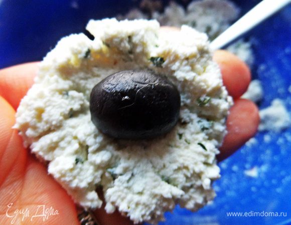 Берём ложку массы, расплющиваем и в центр кладём маслинку.