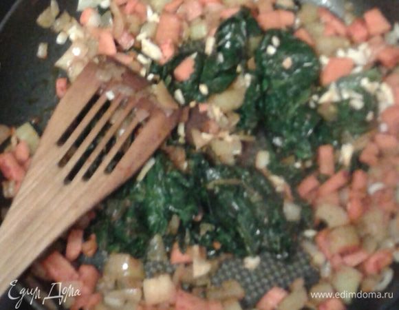 Затем выложить на разогретое в сковородке растительное масло, поджарить до прозрачности лука, выложить мороженый шпинат, продолжать жарить,