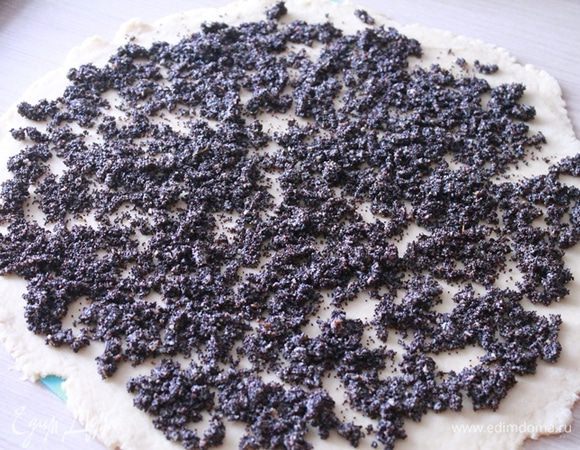 Подготовить целлофановый пакет или силиконовый коврик, присыпать мукой и раскатать тесто в прямоугольный пласт 1 см толщиной. На тесто выложить начинку из мака (1 чайную ложку маковой начинки оставить для присыпки) и свернуть длинным рулетом. Выложить на пергамент, сверху присыпать маковой начинкой.