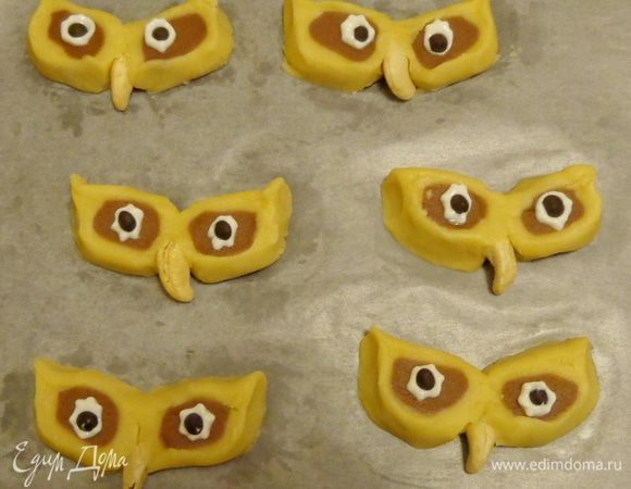 Замерзшее тесто разрезать приблизительно на 30 кружков. Плотно соединить кружки попарно, вставив  между ними орешек. Глазки сделать с помощью крем-сыра, на который положить шоколадные капельки. 