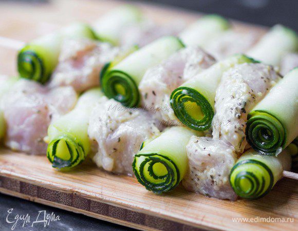Шпажки окунуть в воду на 10 минут, чтобы они не пригорали в процессе готовке на гриле. Свернуть цуккини в рулетики, поочередно нанизывать на шпажку кусочек курицы и рулетик цуккини.