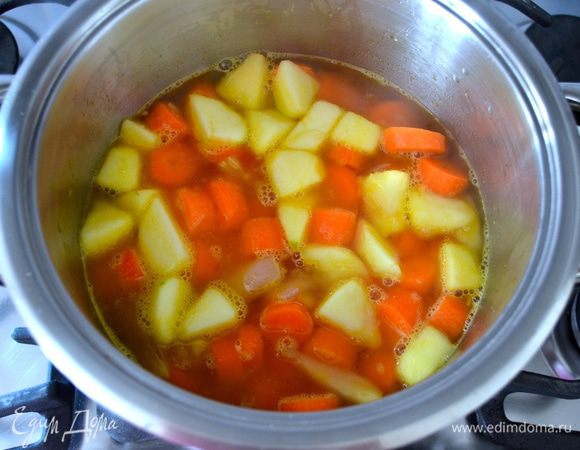 Залить все горячим (!) овощным бульоном, посолить по вкусу и варить на среднем огне 30 минут или до готовности моркови.
