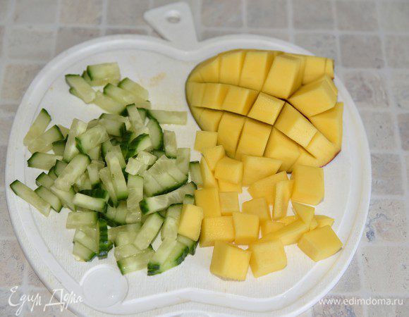 Огурец порезать небольшой соломкой. Манго почистить и нарезать кубиками.
