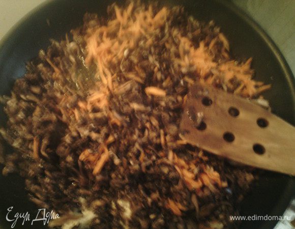 В сковороду налить оливковое масло и положить шампиньоны и морковь, посолить, добавить специи, накрыть крышкой и готовить 5 минут на сильном огне. Шампиньоны выпустят воду, снять крышку добавить тертый чеснок и готовить на медленном огне 10 минут. 