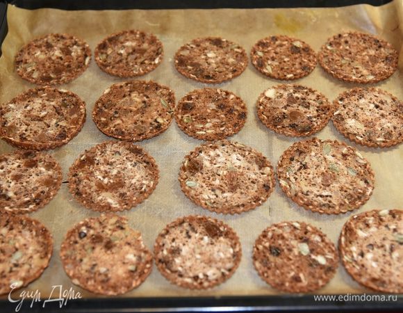 Включить разогреваться духовку до 120 градусов. Противень застелить бумагой для выпечки. Хлеб нарезать максимально тонкими ломтиками (у меня получилось где-то по 2 мм толщиной ножом-пилой) и выложить в один слой на противень. После морозилки хлеб прекрасно режется - не крошится. 
