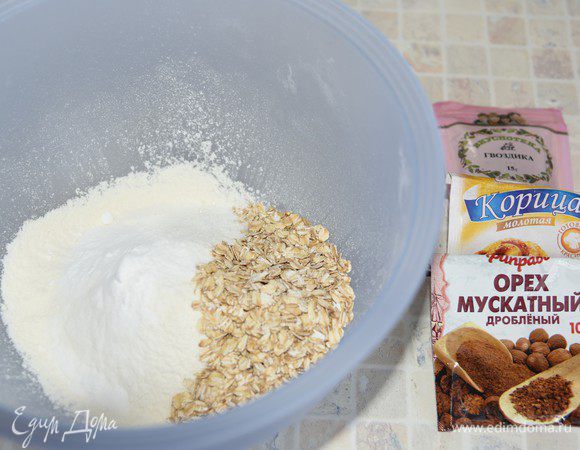 В большой миске смешать муку, овсяные хлопья, соду, пряности и соль. 