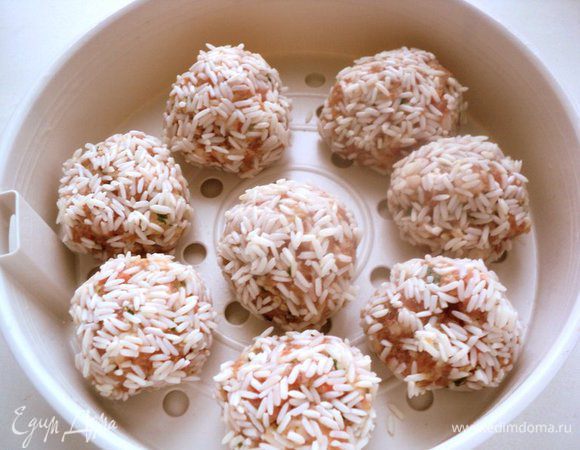 Мокрыми руками сформировать круглые тефтели диаметром 3 см, обвалять в рисе и выложить в чашу пароварки. В пароварку налить воду, положить 1-2 лавровых листика, установить чашу с тефтелями и готовить 35-40 минут.