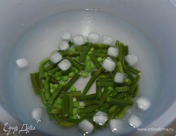Приготовим гарнир. Стручковую фасоль и горошек опустить в кипящую подсоленную воду и варить до готовности (5-7 минут после закипания). Затем сразу поместить в миску с ледяной водой, чтобы остановить тепловую обработку и сохранить зеленый цвет овощей.