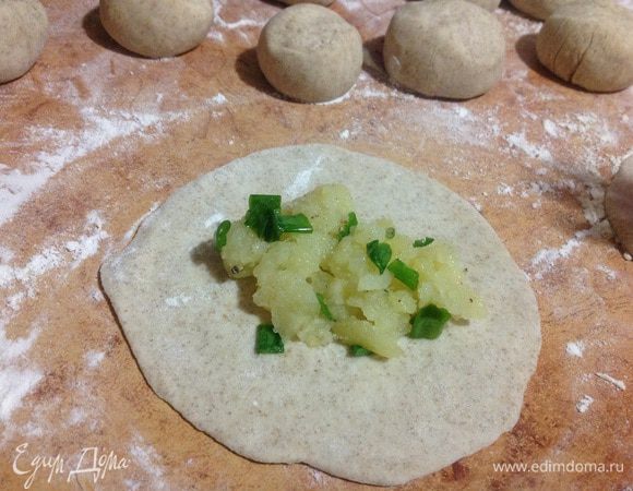 Каждый шарик раскатать как можно тоньше. Выложить начинку, 1-2 ч. ложки.