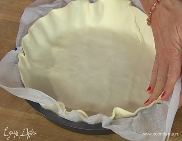 Форму для выпечки выстелить пищевой бумагой, выложить тесто так, чтобы получились бортики, и часто наколоть вилкой.