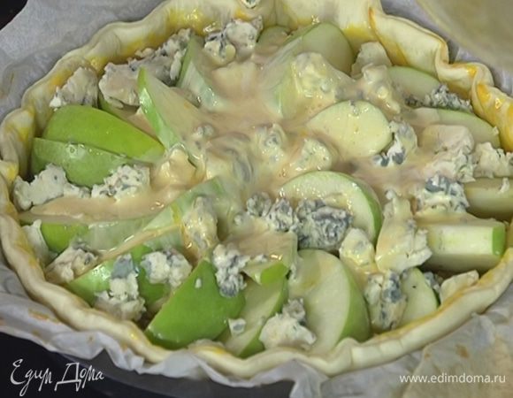 Сверху веером выложить яблоки, посыпать их голубым сыром и залить все яйцами со сливками.