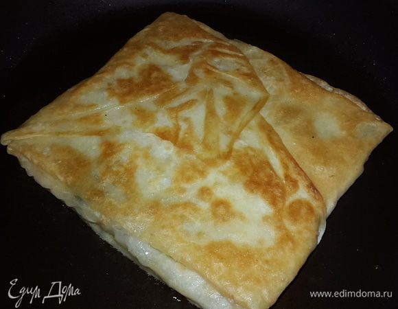 Разогреваем в сковороде оливковое масло, обмакиваем конвертик перед жаркой в теплую воду и обжариваем с двух сторон до румяной корочки. Можно немного солить с каждой стороны, т.к. тесто пресное.