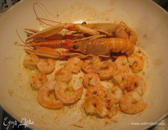В отдельной сковороде на сильном огне обжарить на оливковом масле с зубчиком чеснока креветки и лангустины. Посолить, поперчить красным острым перцем. 