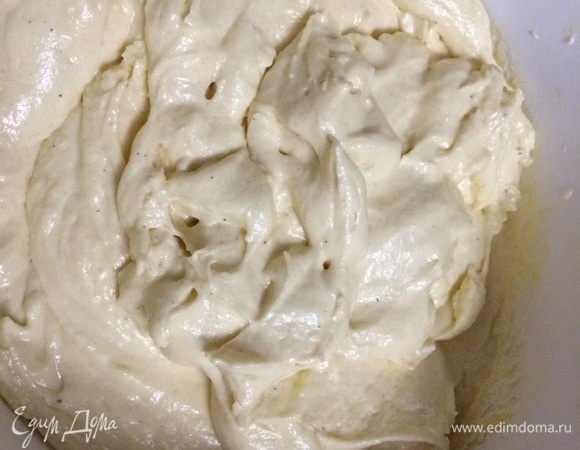 Уменьшите скорость миксера до минимальной и добавьте в два-три этапа просеянную муку с разрыхлителем, затем йогурт.
Получите тесто, напоминающее очень густую сметану.