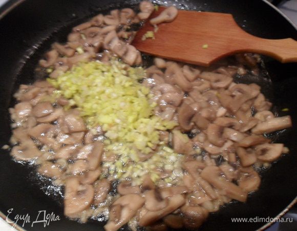 Влить соевый соус, кунжутное масло и лимонный сок. Добавить мелко нарезанный перец чили и белую часть зеленого лука. Жарить еще 5 минут.