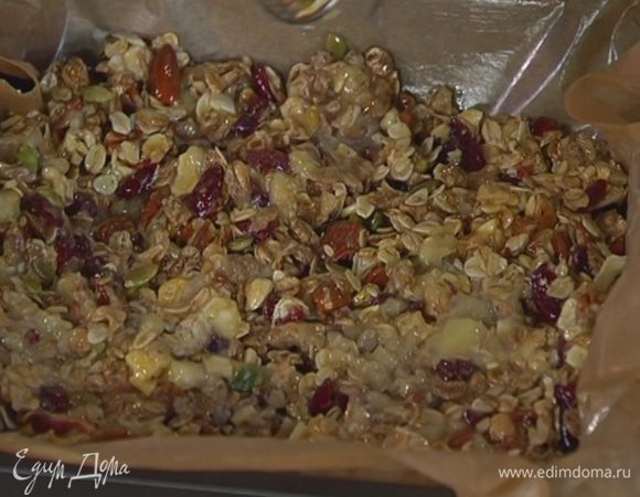 Небольшую глубокую форму для выпечки выстелить пищевой бумагой, смазанной оставшимся сливочным маслом, выложить фруктово-ореховую массу и равномерно распределить.