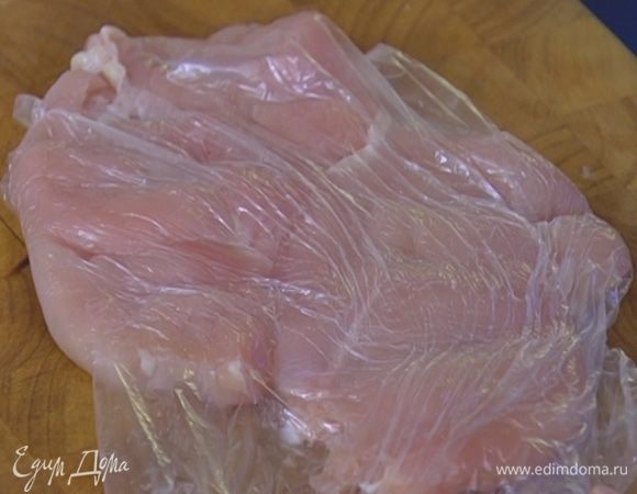 Куриное мясо поместить в целлофановый пакет и отбить скалкой.