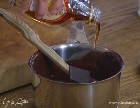 Приготовить шоколадный ганаш: в оставшуюся половину растопленного шоколада со сливками добавить еще 100 г горького шоколада, влить кленовый сироп, перемешать и прогревать на медленном огне, постоянно помешивая деревянной лопаткой, чтобы шоколад полностью растопился.