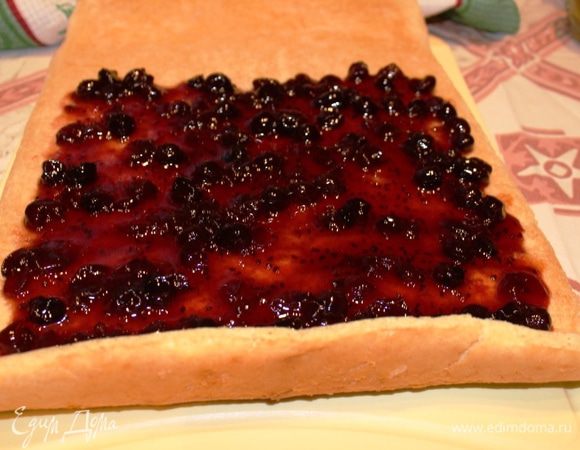 Смазать внутреннюю сторону бисквита вареньем или джемом и сразу свернуть рулет (он хорошо поддается пока горячий). В составе ингредиентов указана одна банка, у меня ушло примерно 350 грамм (половина 750-граммовой банки).