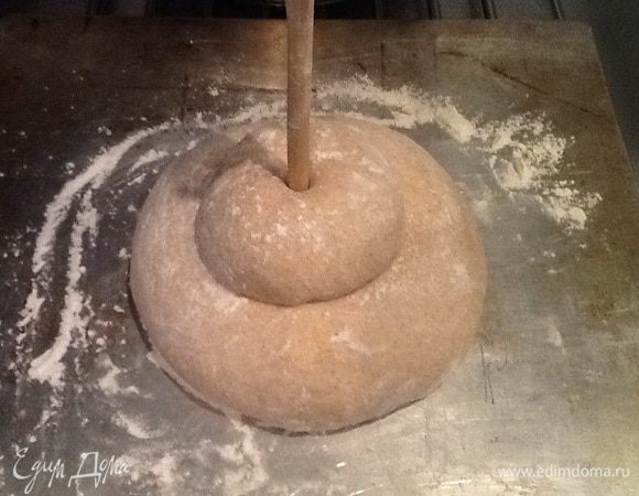 Формируем хлеб. Подкатываем наши кусочки в достаточно плотные колобки и укладываем маленький на большой, а в центр маленького колобка помещаем ручку деревянной ложки, как-бы скрепляя всю конструкцию.