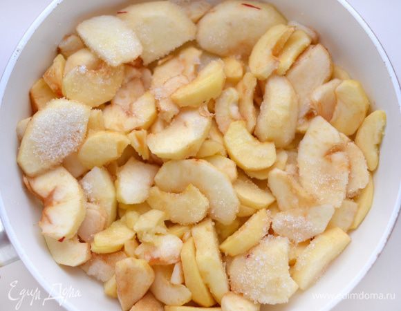 На сковороде растопить сливочное масло (50 г). Добавить яблоки. Слегка поджарить их. Добавить сахар (50 г). Перемешать.