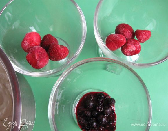В порционную стеклянную посуду положить ягоды для нижнего слоя, часть смородины я протерла через сито, часть смородины оставила целой. Можно разрезать клубнику пополам или на четыре части.
