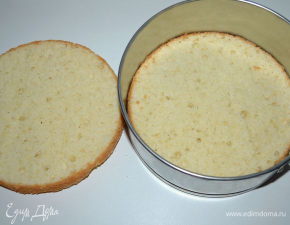 Бисквит остудить на решетке, разрезать пополам. Хорошо пропитать бисквитные коржи сахарным сиропом (у меня сироп шиповника, разведенный  водой). Одну половину выложить в форму, в которой он пекся.