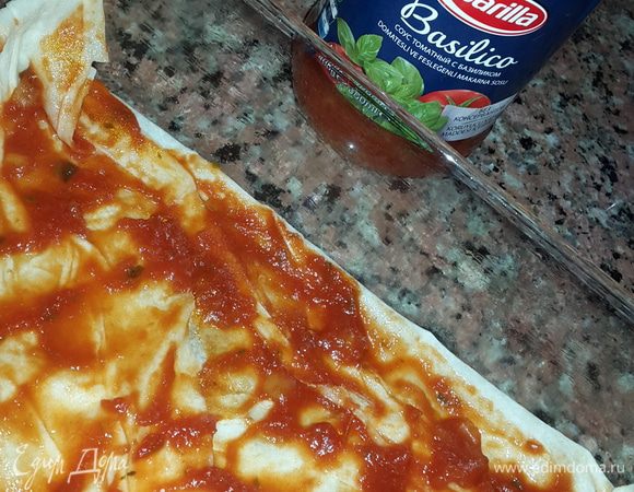 Форму для запекания смазываем оливковым маслом и застилаем лавашом в один слой. Смазываем лаваш томатным соусом.