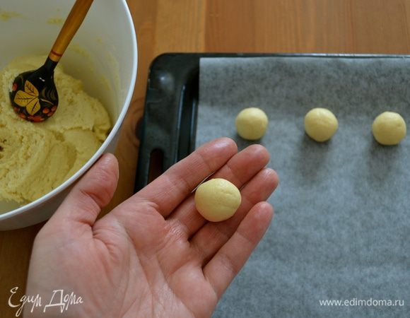 Духовку разогреть до 180°C. Противень застелить пекарской бумагой. Сформировать из теста 40 шариков и выложить их на противень на расстоянии 2-2,5 см друг от друга.
