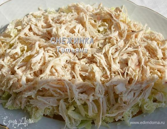 Капусту нарезаем тонко. Укладываем на общее блюдо первым слоем. Куриное филе разбираем на волокна. Кладём поверх капусты.