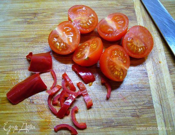 Помидоры черри вымыть, разрезать пополам.
Перец чили нарезать полукольцами.
