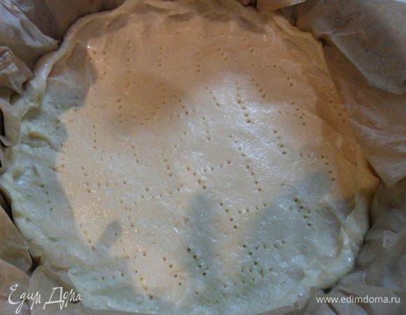 Через час в форму застеленную пергаментом выкладываем тесто, делаем бортики, накалываем вилкой и отправляем в разогретую до 200 С духовку.  Духовка должна быть хорошо разогрета, чтоб тесто не стекло.