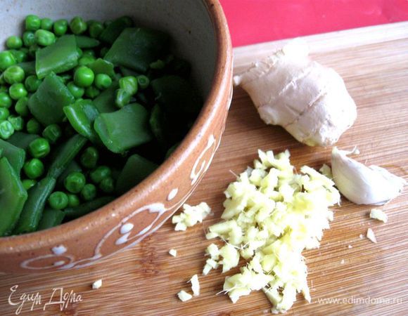 Слегка отварить  крупно порезанную фасоль в стручках и горошек  в небольшом количестве  подсоленной кипящей воды в течение 1-2  минут, откинуть на сито. Можно обойтись без этой процедуры, тогда положить эти овощи при жарке чуть раньше, чем указано в шагах. Чеснок и имбирь почистить, мелко порубить.