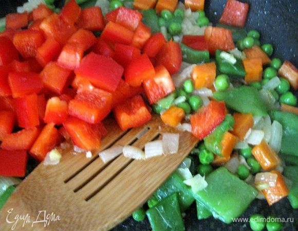 Затем добавить чеснок и имбирь, если у вас перец чили свежий (у меня в порошке), то добавьте его сейчас, мелко порезав, без семян, помните, что он очень жгучий и достаточно небольшого кусочка, и готовить, помешивая, еще  1-2 минуты. Затем  очередь фасоли в стручках и гороха. Добавить сладкий перец.