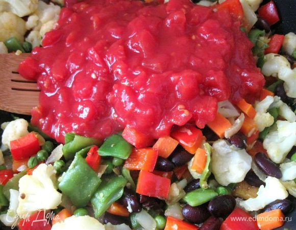 Добавить помидоры в собственном соку и воду (можно овощной бульон).  Довести до кипения и добавить  стебли кориандра, мелко порезанные. Готовить 10 минут, периодически помешивая. 