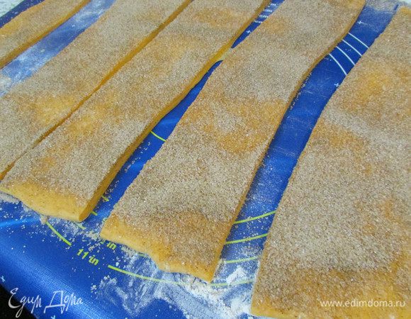 Слегка присыпать мукой рабочую поверхность. Выложить тесто и раскатать в прямоугольник. Посыпать начинкой и разрезать на 6 полос. полосы сложить друг на друга и ещё перерезать их 4 раза.