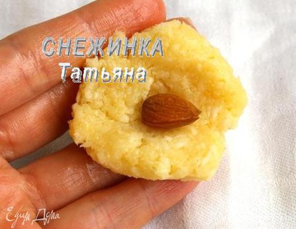 Отрываем от охлаждённой основы для конфет немного массы. Немного разминаем в ладошке, чтобы получить однородную массу. Делаем из неё лепешку, в центр кладём орешек и облепливаем его, придавая форму шарика. 