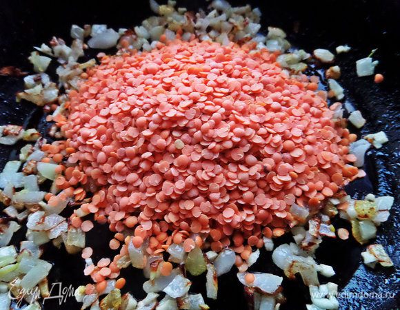 Когда лук позолотиться, высыпаем к нему чечевицу.