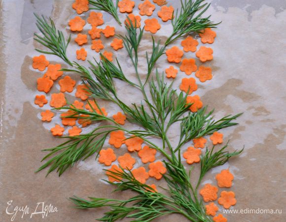 С помощью овощечистки нарезать морковные полосы, плунжером сделать цветочки. Уложить на застеленный пекарской бумагой противень, формируя соцветия мимозы, чередовать веточками укропа. 