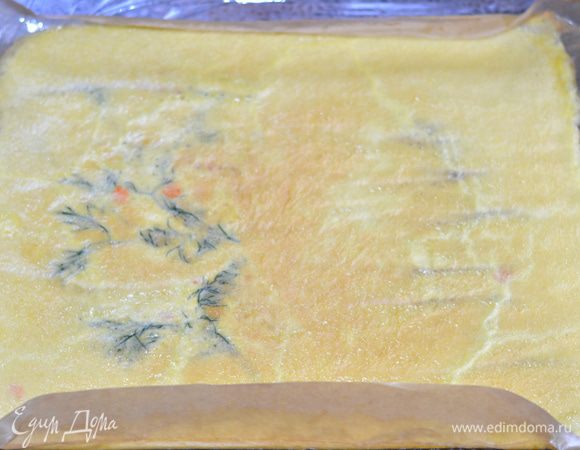 Достаем из духовки омлет.  
Переворачиваем его на пекарскую бумагу, аккуратно, чтобы не повредить, снимаем пергамент, на котором он выпекался. Кладем сверху или пищевую пленку, или этот же пергамент, с помощью него мы будем скручивать рулет. Переворачиваем. Рисунок остается внизу. 
Распределяем начинку. Аккуратно скручиваем. Заворачиваем в пищевую пленку и даем постоять в холодильнике минут 20.