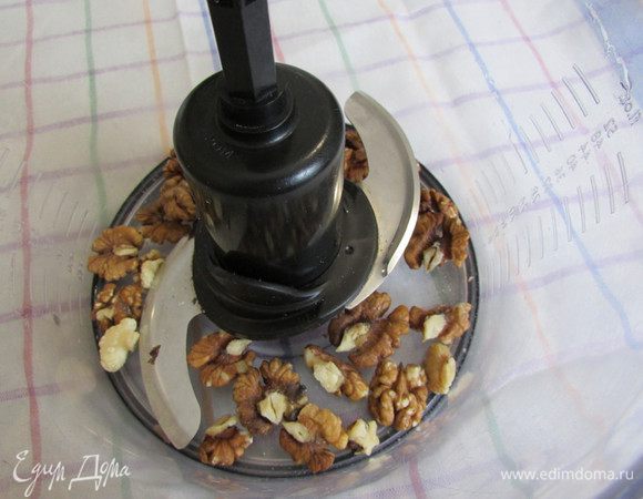 Орехи выложить в чашу блендера и мелко порубить.
