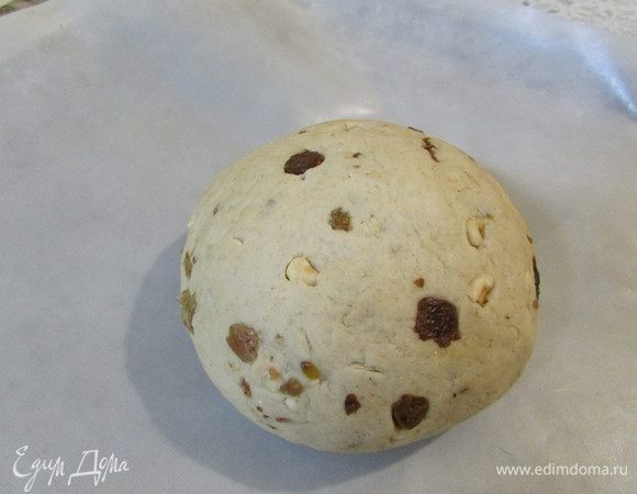 Через 40 минут добавить изюм и орехи в тесто, хорошо вымесить. Сформировать из теста 2 шара, накрыть салфеткой и оставить в тёплом месте для подъёма, примерно на 1,5 часа. Тесто должно увеличиться в 2 раза.