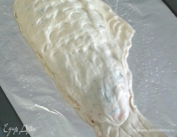 Делаем форму рыбки, ложкой продавливаем тесто в форме чешуи, а также делаем насколько отверстий, чтобы мог выходить пар. Сверху нашу рыбку смажем растительным маслом.