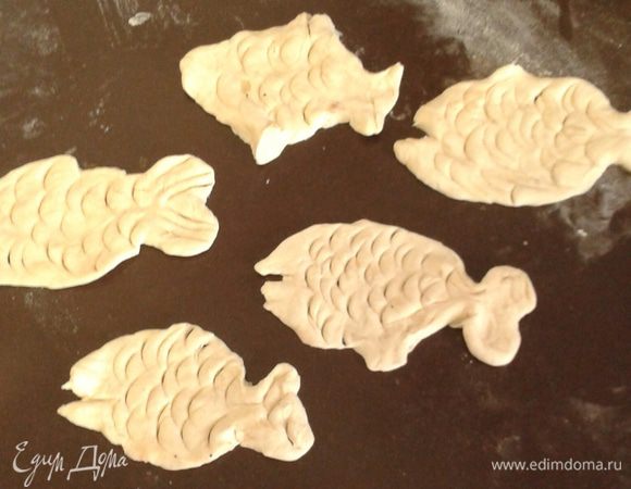 Лишнее тесто обрезаем, а из остатков лепим небольших рыбок. Запекаем рыбу в духовке при 200 градусах около 20 минут, пока тесто не зарумянится. 