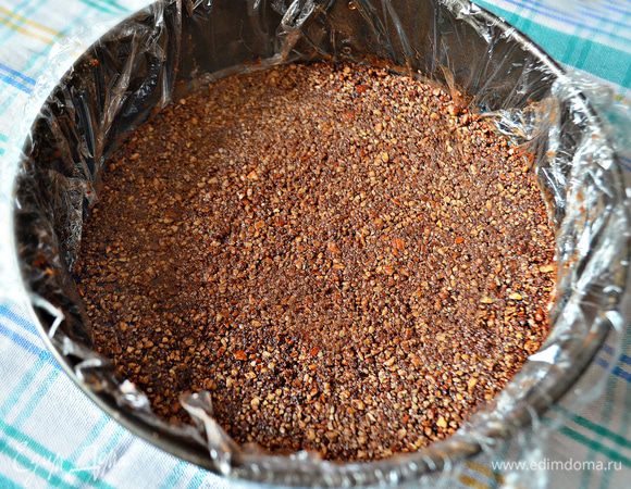 Дно и стенки формы для торта обернуть пищевой плёнкой. Я использовала форму d = 24 см. Ореховую массу переложить в форму, примять ко дну лопаткой, чтобы получился ровный корж. Убрать в холодильник.